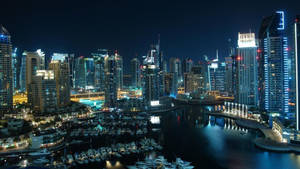 現代城市天際線的夜景，建築物發光，碼頭停滿船隻。 — 城市 壁紙