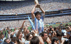 Diego Maradona 在球場上被歡呼的球迷包圍，手持世界盃獎盃。