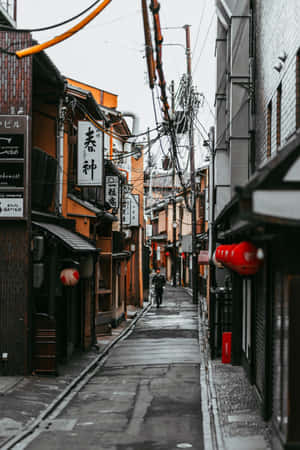 京都一條狹窄的雨巷，有傳統木建築和紅燈籠。