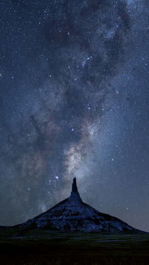 在星空下，銀河可見的山峰剪影。