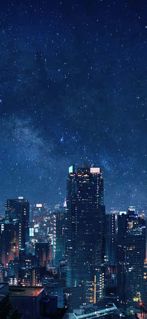 夜晚城市景觀，星空下，銀河系可見，建築物燈火通明。