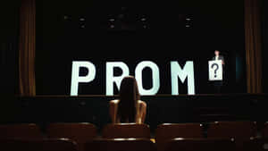 女孩看著帶有「PROM」和問號牌子的舞台。