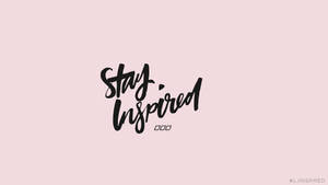 粉紅色背景上黑色畫筆字體的Stay Inspired勵志文字
