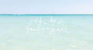 平靜的藍綠色海洋上白色字體寫著 salt in the air sand in my hair。