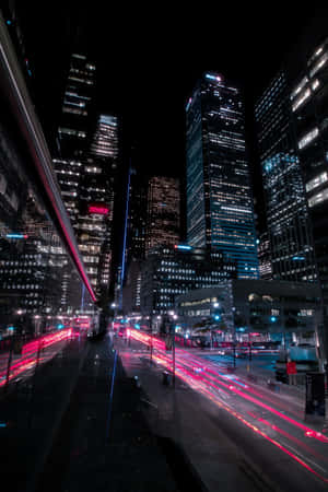 夜晚的城市街道，閃爍的摩天大樓和模糊的紅色車燈。 — Vivo Pad 壁紙