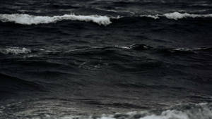 陰暗的海浪，在憂鬱的光線下翻滾著白色泡沫。 — 黑色美學 壁紙