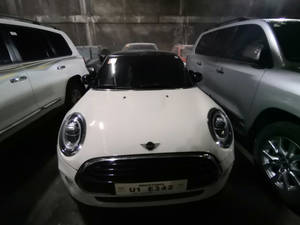 白色Mini Cooper停泊在混凝土地下停車場，旁邊有其他汽車。 — 白色美學gif 壁紙
