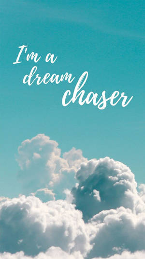 藍綠色天空，有蓬鬆的白雲和白色手寫文字寫著「I'm a dream chaser」。