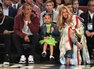 Jay Z、Beyoncé 和女兒 Blue Ivy 在籃球場邊。
