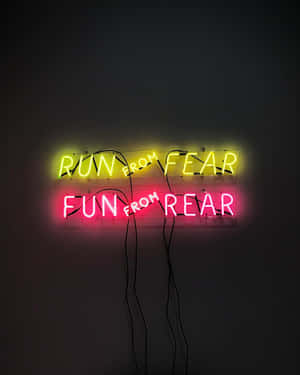 兩塊霓虹燈牌在暗牆上，寫著 run from fear 和 fun from rear。