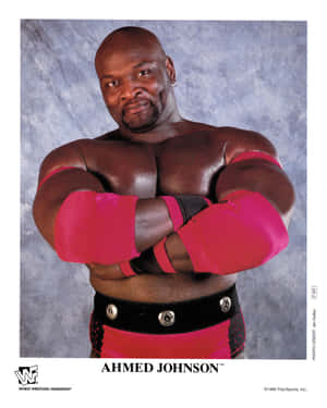 職業摔角手 Ahmed Johnson 穿著粉紅色和黑色裝備交叉雙臂擺姿勢。 — 摔角 GIF 壁紙
