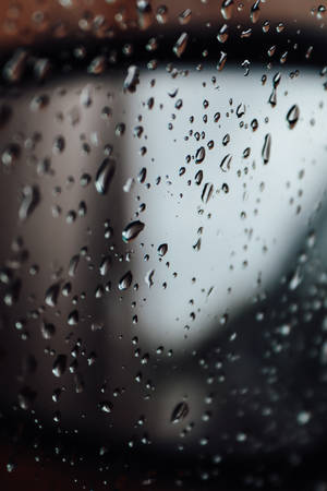 玻璃上雨滴的特寫，背景模糊