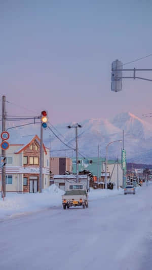 雪街、皮卡車和山脈在黃昏