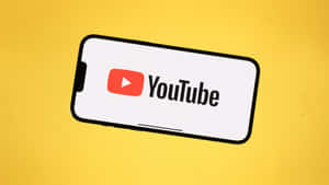 智能手機在黃色背景上顯示 YouTube 應用程式標誌。 — YouTube 壁紙