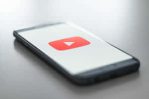 智能手機在乾淨的白色背景上顯示 YouTube 應用程式圖標。 — YouTube 壁紙