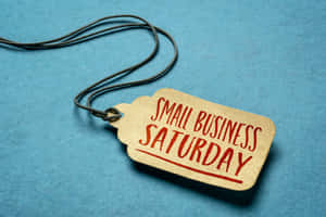 一個米色紙標籤，上面有紅色手寫文字，寫著 Small Business Saturday。