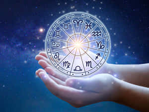 在星空下雙手捧著一個發光的星座輪盤。 — 星座 壁紙