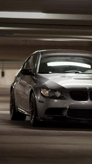 銀色BMW M3轎跑車停泊在地下停車場，上方燈光模糊。