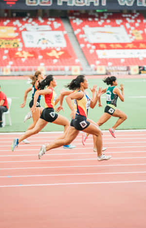 女性運動員在比賽期間在紅色跑道上衝刺。 — Galaxy Tab S9 壁紙