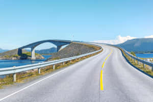 蜿蜒的海岸道路，橋樑橫跨水面，背景有山脈