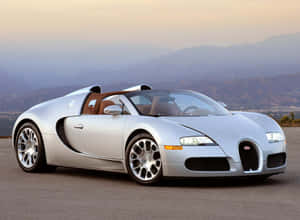 銀色 Bugatti Veyron 超級跑車在日落時分停在山路上。