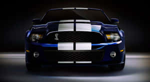 藍色Shelby GT500跑車，帶有白色賽車條紋，在攝影棚燈光下。
