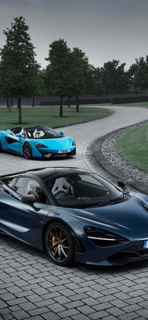 兩輛McLaren跑車停泊在石路上，背景有樹木。 — Xiaomi 壁紙