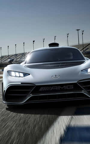銀色 Mercedes-AMG 賽車在賽道上疾馳，帶有動態模糊效果。 — Galaxy Tab Active 壁紙