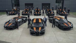 Bugatti員工團隊在現代建築前與黑色和橙色超跑合影。