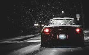 黑色跑車配紅色尾燈在夜間雪地行駛。 — 本田 壁紙