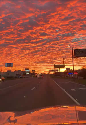 黃昏時分的高速公路，上方是火紅橙色的天空。