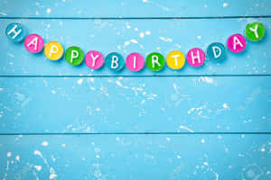 Happy Birthday 字母在彩色圓圈中，背景為帶有油漆飛濺的藍色木質表面。