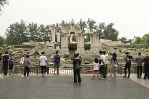 訪客在多雲的日子裡在公園裡走過古老的石頭廢墟。 — 唐人街 GIF 壁紙