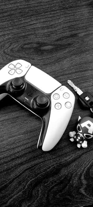 PlayStation 5手掣連同鎖匙扣和美國隊長人偶在木質表面上。