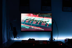 遊戲設置，屏幕上顯示Cyberpunk 2077，在黑暗的房間裡有發光的外設。
