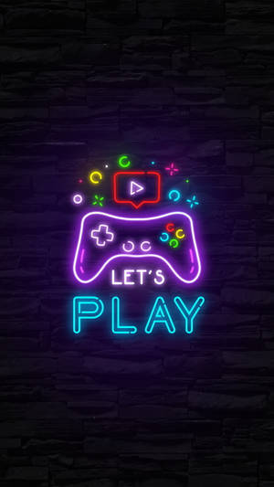 霓虹燈遊戲控制器標誌，上面寫著「LET'S PLAY」，在石牆上發光。