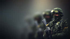 一名全副武裝的士兵手持步槍，背景有隊友。