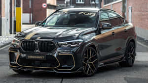 黑色BMW X6 M配金色飾邊停在城市街道上。 — 寶馬X6 M 壁紙