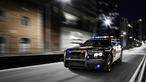 警車在夜間穿過城市，閃爍著燈光。