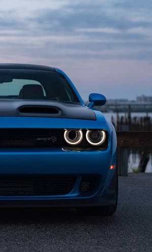 藍色 Dodge Challenger SRT Hellcat 在黃昏時停在水邊。 — 霓虹藍色美學 壁紙