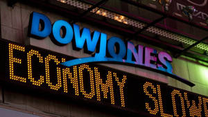 夜間霓虹燈下顯示economy slow跑馬燈的道瓊斯標誌。 — 火影忍者海報 壁紙