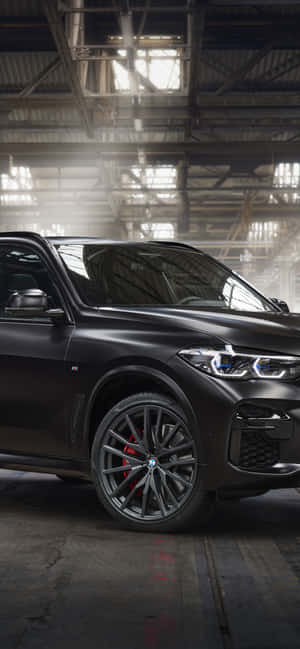 啞光黑色BMW SUV，紅色制動器，在陽光普照的倉庫中。 — Xperia 10 壁紙