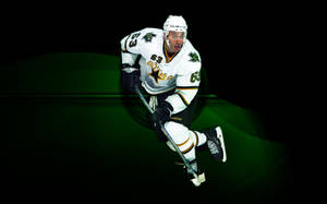 白色球衣冰球運動員持球棒蹲在綠色背景前。