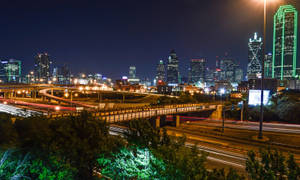 夜間城市，有燈火通明的摩天大樓和流動的車燈。
