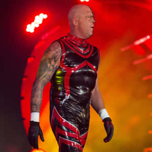 摔角手穿著紅黑套裝在舞台燈光下行走 — WWE GIF 壁紙