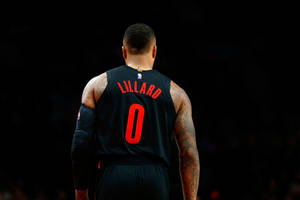 籃球運動員 Damian Lillard 身穿黑色球衣，紅色零號，背對鏡頭。