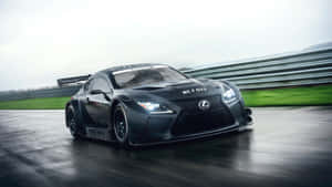 黑色 Lexus RC F GT3 賽車在潮濕賽道上疾馳，帶有動態模糊效果。