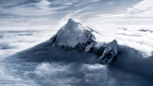 白雪覆蓋的山峰聳立在厚厚的雲層之上。