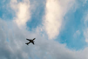 一架飛機在黃昏時分飛過多雲的天空。