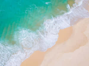 綠松石色的海浪從上方輕輕湧上金色沙灘。